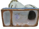 a figurine of a woman laying down on a bed