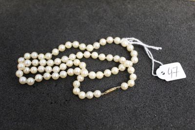 a white pearl necklace with a tag on it