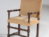 une vieille chaise en bois dont l'assise est recouverte d'un tissu beige