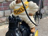 a statue of a man on a motorcycle with a gas pump