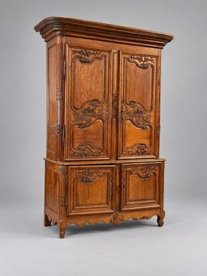 une armoire ancienne en bois, ornée de sculptures sur les portes