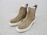 beige sued boots with white soles on a white surface