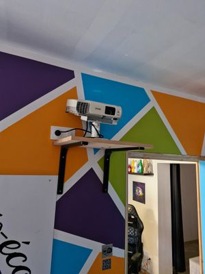 a picture of a room with a mirror and a projector on the wall