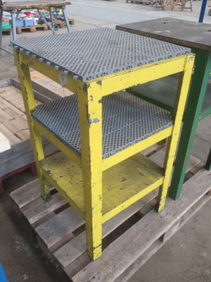 une table jaune et verte posée sur une palette dans un entrepôt