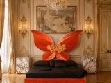 un lit orné d'un papillon rouge, au milieu d'une pièce