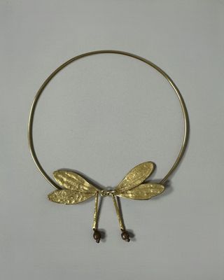 Collier avec une libellule dorée sur fond blanc