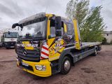 un camion jaune garé sur la terre battue