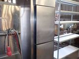 stainless steel refrigerator in a warehouse with shelves and shelves on either side of the refrigerator