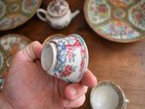 a person holding a cup and saucer on a table