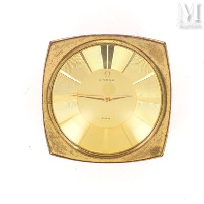 a gold clock that is sitting on a white surface