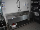 un évier en acier inoxydable dans une cuisine, avec un robinet posé sur le plan de travail
