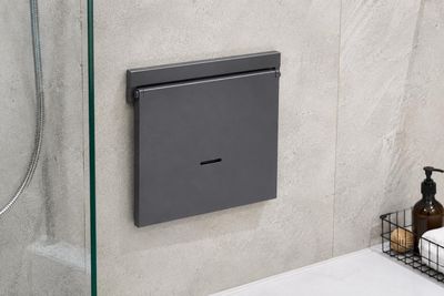 une salle de bains équipée d'une porte de douche en verre et d'un distributeur de savon
