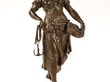 statue en bronze représentant une femme tenant un chien, posée sur un socle en marbre