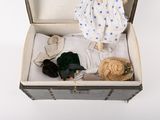 a doll in a suitcase with clothes and a teddy bear