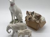 four figurines of dogs and a cat in a box