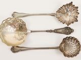 three spoons that are sitting on a white surface