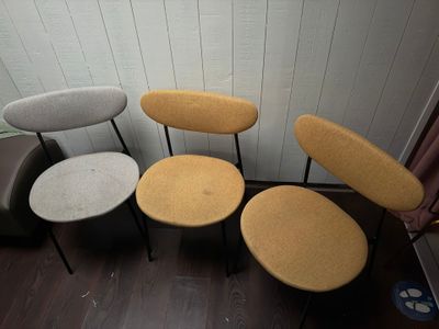 Quatre chaises sont alignées contre un mur dans une pièce