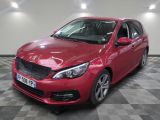 la voiture rouge est garée sur un sol en damier dans le garage