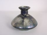 a small blue vase sitting on a white table