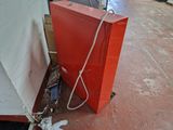 a red box sitting on the floor next to a white wall
