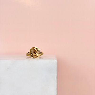 une bague en or posée sur un bloc de marbre blanc