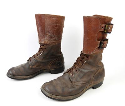 une paire de bottes en cuir marron, munies de boucles et de lacets