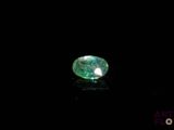 a close up of a green diamond on a black surface