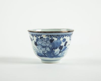 un petit bol bleu et blanc orné de fleurs