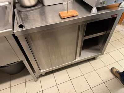 a stainless steel kitchen with a sink and a toaster on the counter