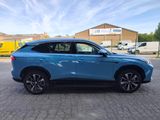 a blue suv parked in a parking lot next to a building