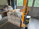 a picture of a forklift in a warehouse with stacks of wood