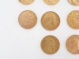 several gold coins are arranged in a row on a white surface