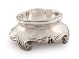 a silver bowl that is sitting on a white surface