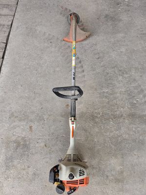 a picture of a string trimmer sitting on the sidewalk
