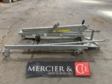 two trailer dollys sitting on the ground next to a sign that says mercierr & co