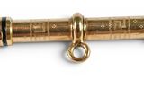 a close up of a gold plated metal curtain rod with a brass clasp