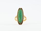 une bague en or avec une pierre verte au centre