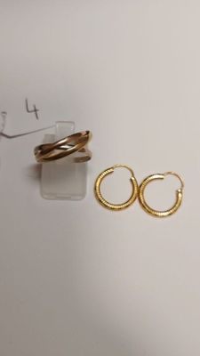 two pairs of gold hoop earrings on a white surface