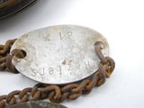 a chain with a tag attached to it on a table