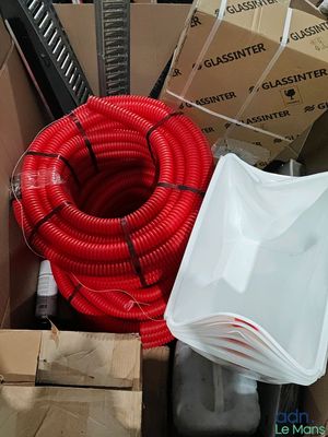 a red hose sitting inside of a box next to other boxes