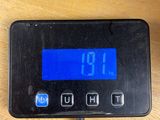 a digital clock that is on the table next to a cup of coffee