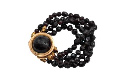 a close up of a black beaded bracelet with a gold clasp