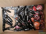 une boîte remplie de rouges à lèvres et de stylos