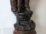 a statue of a man and a woman standing on top of a rock