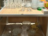 de nombreux verres et vases posés sur une étagère dans un magasin