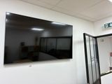 un grand téléviseur à écran plat fixé au mur dans une pièce