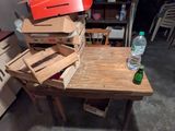 une pile de boîtes à pizza posées sur une table sur laquelle se trouve une bouteille d'eau