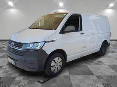 Une camionnette blanche est garée dans une pièce au sol carrelé en damier.
