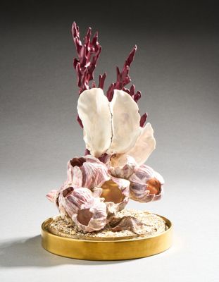 une assiette dorée ornée d'une fleur sur un fond blanc