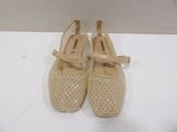pair of beige shoes sitting on top of a white table